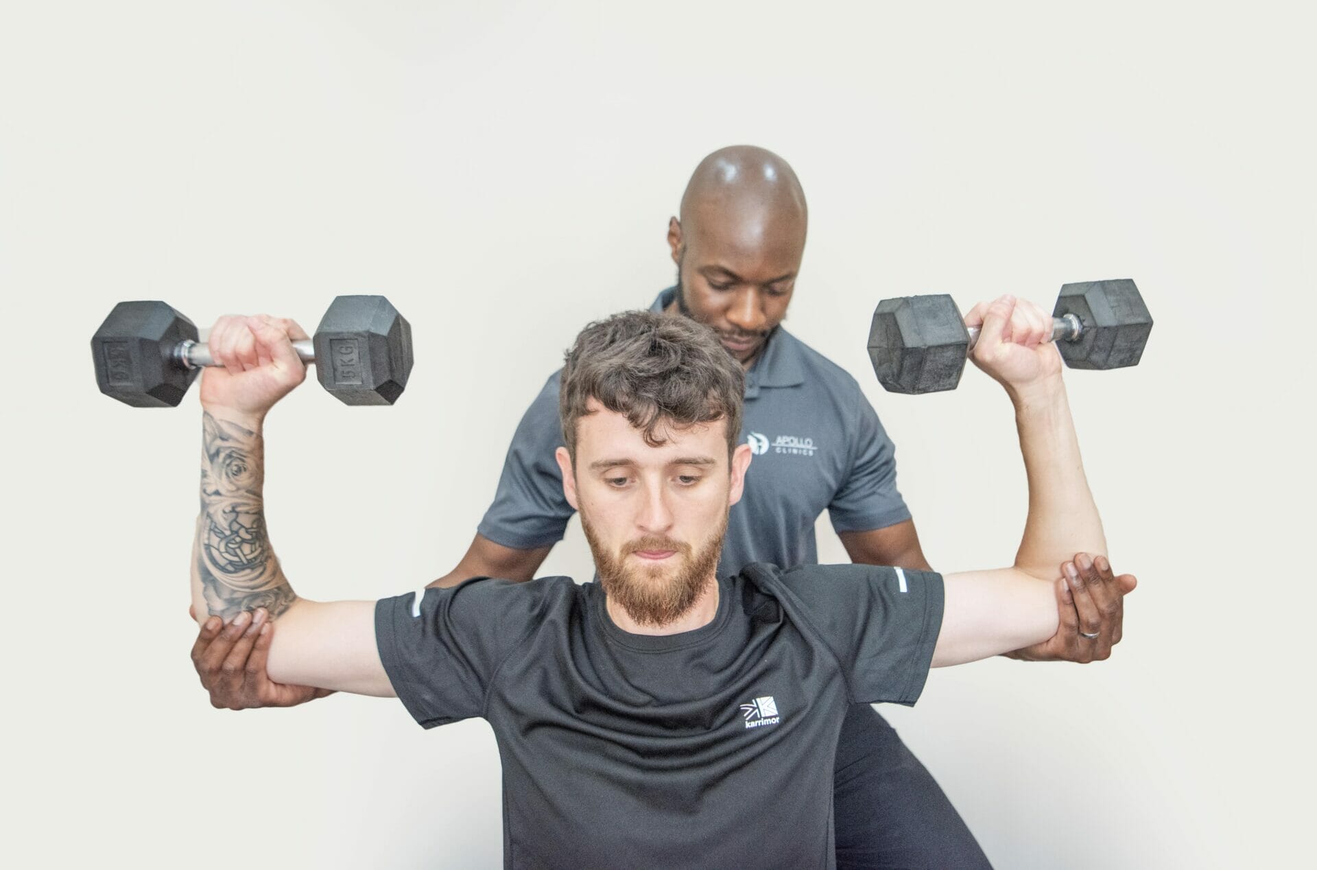 Physiotherapist helps patient lift weights during Sevenoaks Physiotherapy treatment